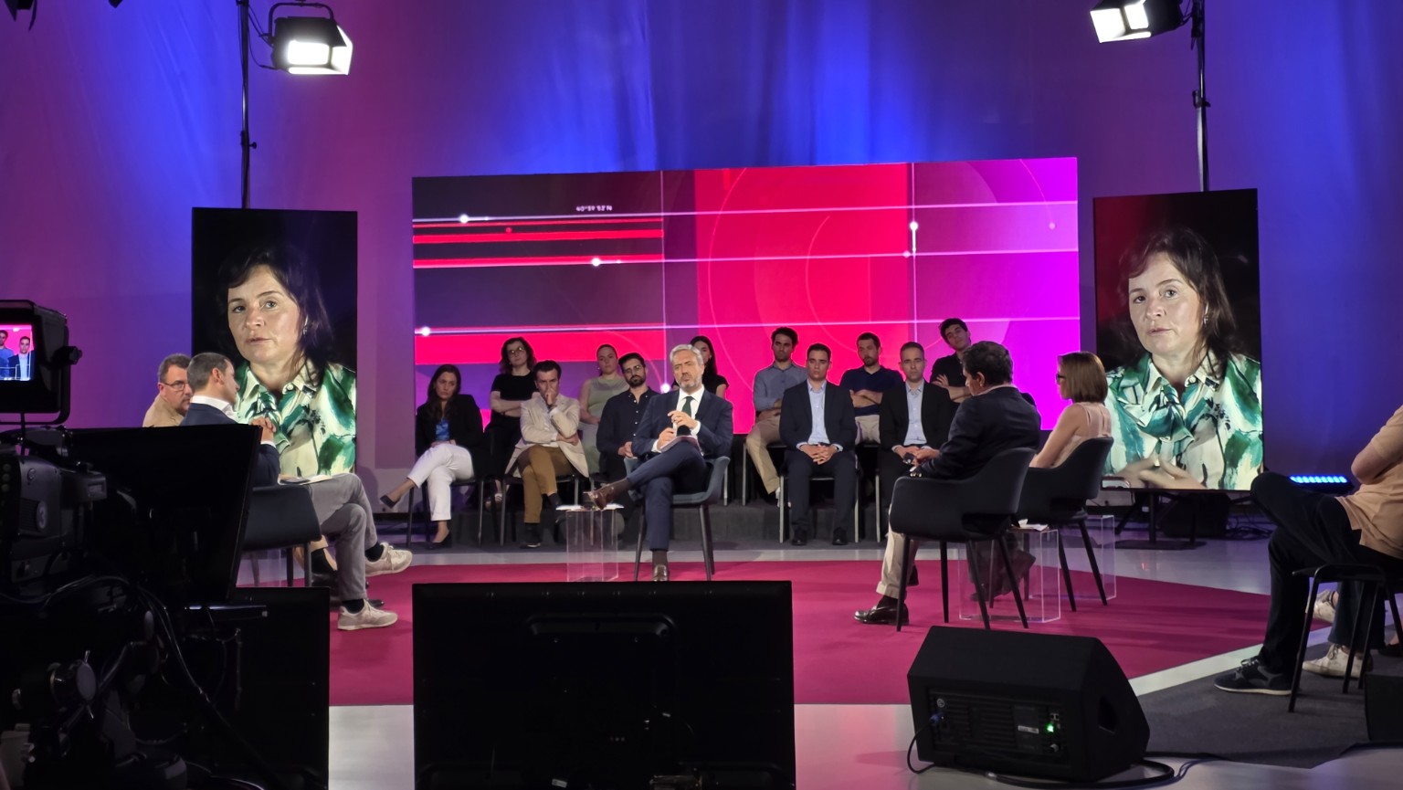 Estúdio de televisão com ecrãs LED e participantes